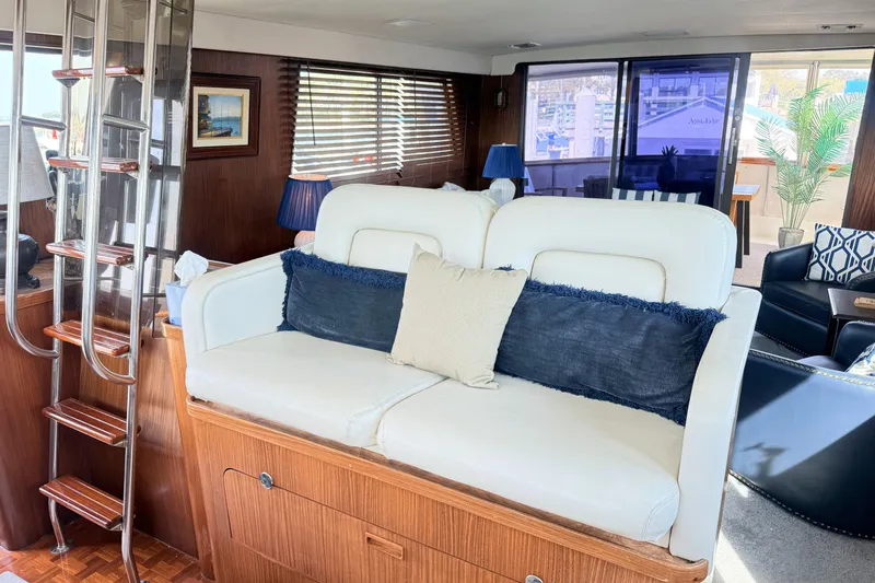 Lady Malan Yacht Photos Pics Interior of 1987 Hatteras 54 Motor Yacht with white seating and wooden accents.