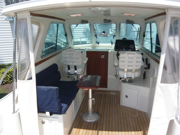 Last Hurrah Yacht Photos Pics 2008 Back Cove 29 boat interior with seating, table, and helm station.