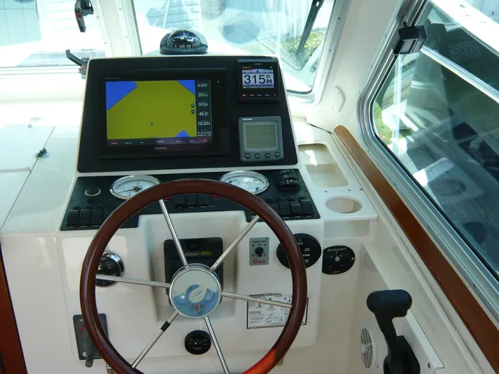 Last Hurrah Yacht Photos Pics 2008 Back Cove 29 helm with navigation display and steering wheel.