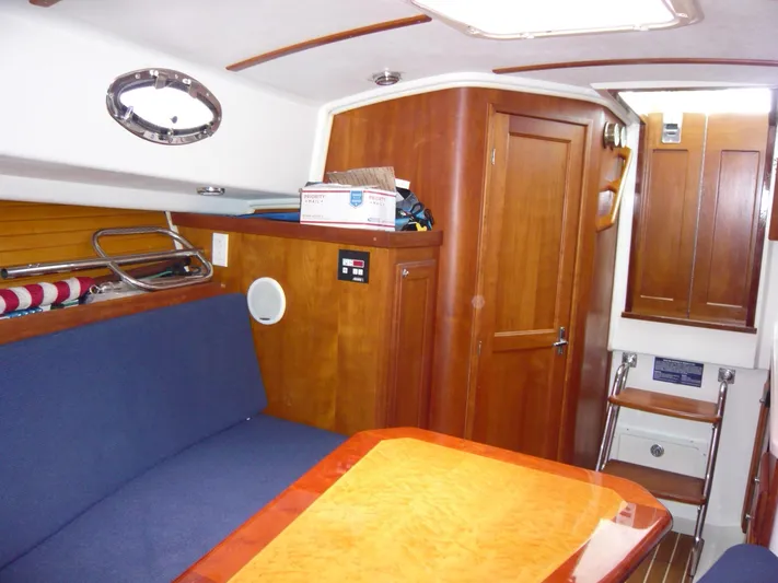 Last Hurrah Yacht Photos Pics 2008 Back Cove 29 interior with wooden cabinetry, blue seating, and a polished table.