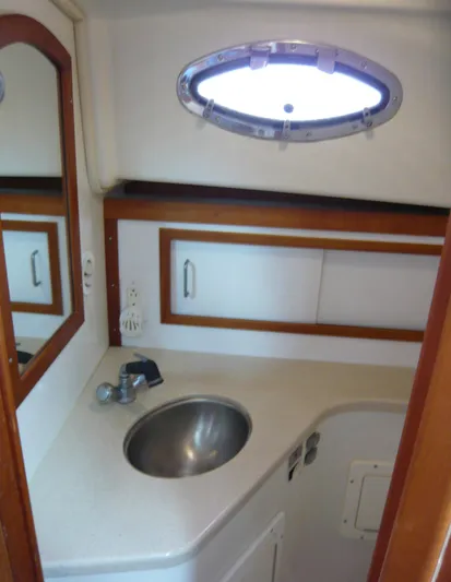 Last Hurrah Yacht Photos Pics 2008 Back Cove 29 yacht bathroom with sink, mirror, and storage cabinets.