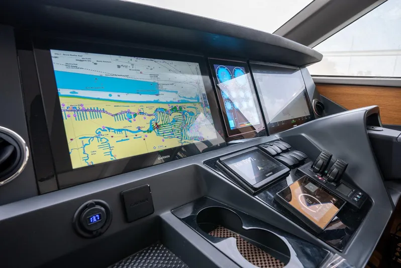 Fly By Yacht Photos Pics Control panel of 2019 Princess V65 yacht with navigation screens and controls.