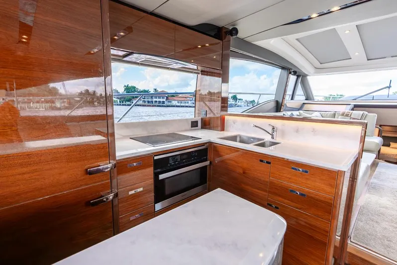Fly By Yacht Photos Pics Luxurious kitchen interior of 2019 Princess V65 yacht with modern appliances and wood finish.