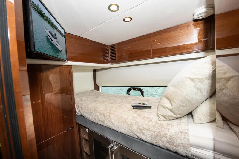 Fly By Yacht Photos Pics Luxurious cabin interior of 2019 Princess V65 yacht with TV and cozy bedding.