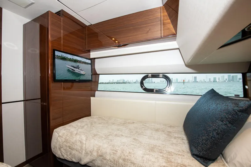 Fly By Yacht Photos Pics Luxurious 2019 Princess V65 yacht cabin with TV, window view, and plush bedding.
