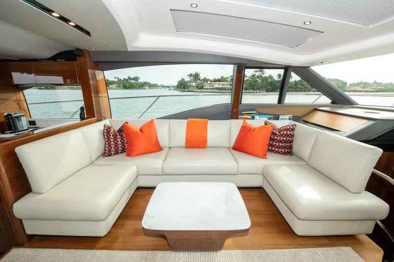 Fly By Yacht Photos Pics Luxurious 2019 Princess V65 yacht interior with white leather seating and vibrant orange pillows.