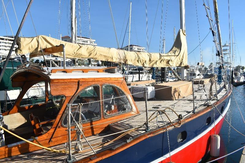 1958 Custom Steel Motorsailor with wooden cabin, docked in marina under clear blue sky.