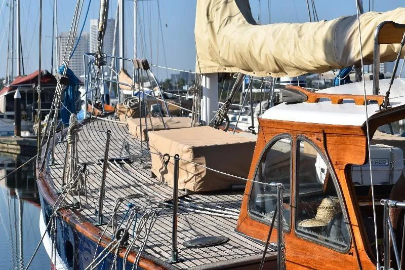 Vintage 1958 Custom Steel Motorsailor yacht docked at marina, showcasing wooden deck and cabin.