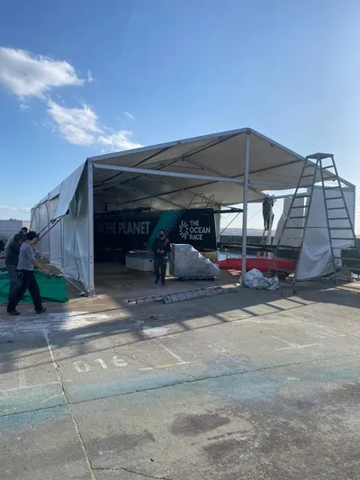  Yacht Photos Pics Outdoor tent with "The Ocean Race" branding, housing a Farr Volvo Ocean 65 yacht.