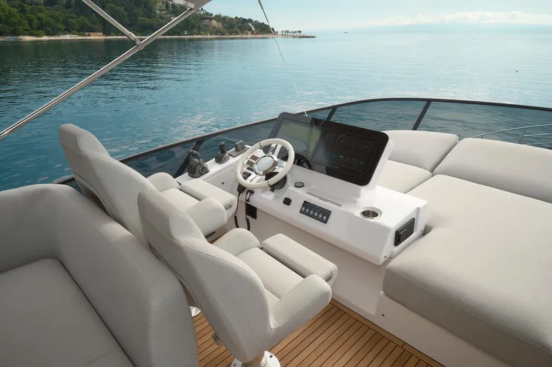  Yacht Photos Pics 2023 Azimut 53 yacht helm with modern controls and plush seating on calm waters.