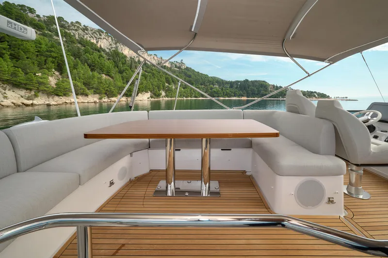  Yacht Photos Pics Luxurious 2023 Azimut 53 yacht deck with elegant seating and scenic coastal view.
