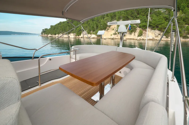  Yacht Photos Pics Luxurious 2023 Azimut 53 yacht deck with elegant seating and scenic coastal view.
