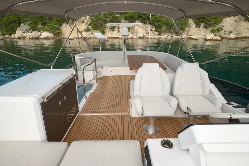  Yacht Photos Pics Luxurious 2023 Azimut 53 yacht deck with seating, wood flooring, and scenic water view.