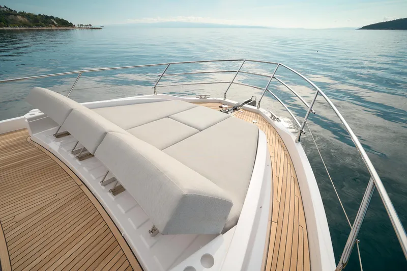  Yacht Photos Pics Luxurious 2023 Azimut 53 yacht deck with sunbed, overlooking serene ocean waters.