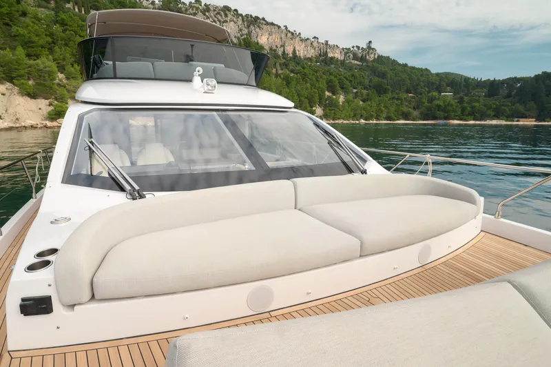  Yacht Photos Pics Luxurious 2023 Azimut 53 yacht with spacious deck and scenic coastal backdrop.