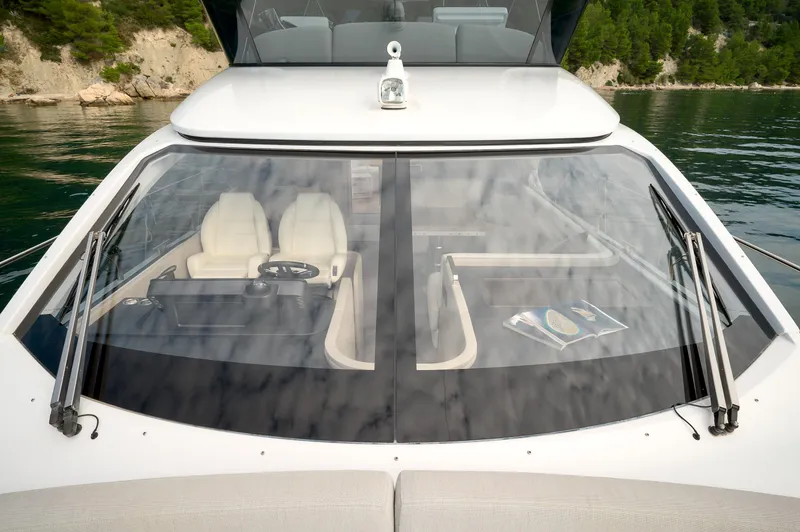  Yacht Photos Pics 2023 Azimut 53 yacht cockpit with dual seats and steering wheel, viewed from the exterior.