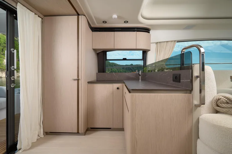  Yacht Photos Pics Luxurious interior of 2023 Azimut 53 yacht with modern kitchen design and scenic window view.