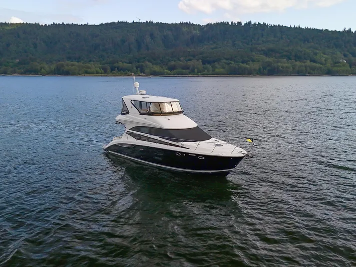 Serenity Yacht Photos Pics 2012 Meridian 441 Sedan yacht cruising on a serene lake with forested hills in the background.