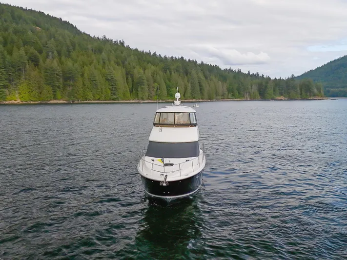 Serenity Yacht Photos Pics 2012 Meridian 441 Sedan yacht on a serene lake with forested hills.