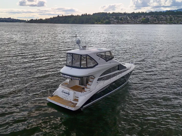 Serenity Yacht Photos Pics 2012 Meridian 441 Sedan yacht on serene water, surrounded by lush landscape.