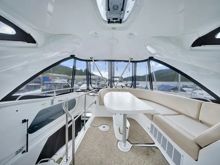 Serenity Yacht Photos Pics Interior of 2012 Meridian 441 Sedan yacht with seating and table, docked at marina.