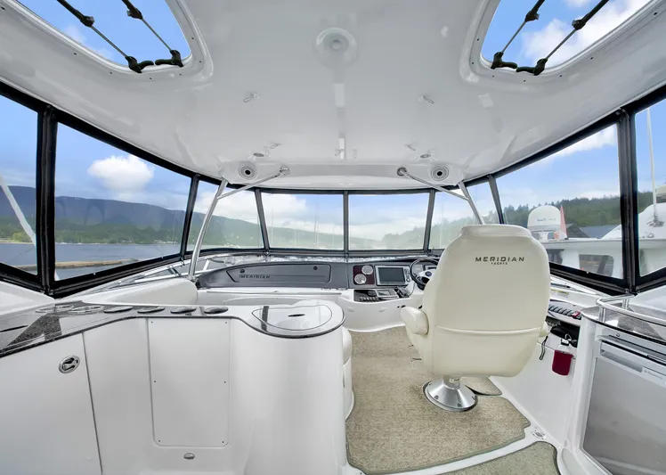 Serenity Yacht Photos Pics Interior view of 2012 Meridian 441 Sedan yacht cockpit with panoramic windows and captain's chair.
