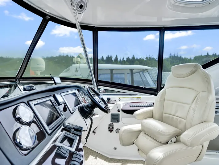 Serenity Yacht Photos Pics Interior of 2012 Meridian 441 Sedan yacht cockpit with luxurious captain's chair and control panel.
