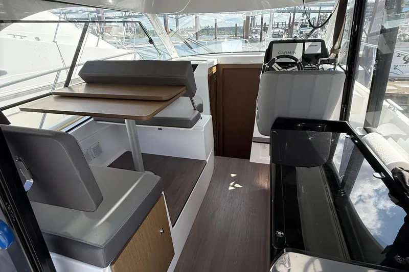  Yacht Photos Pics Interior of 2021 Beneteau Antares 9 boat with seating and navigation area.