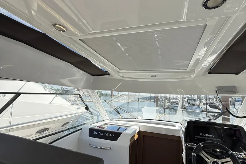  Yacht Photos Pics Interior view of 2021 Beneteau Antares 9 boat, featuring helm and marina background.