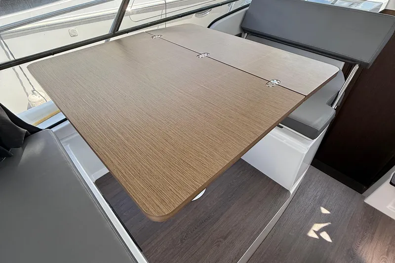  Yacht Photos Pics Interior of 2021 Beneteau Antares 9 with foldable wooden table and seating.