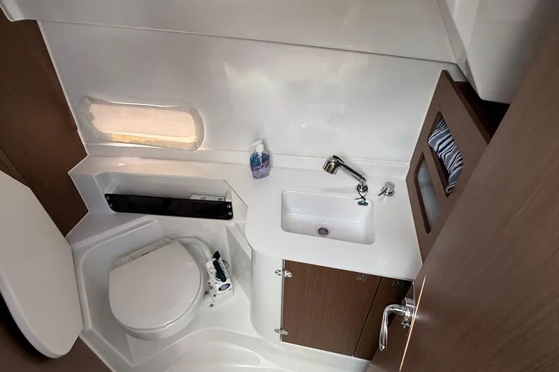  Yacht Photos Pics 2021 Beneteau Antares 9 bathroom with sink, toilet, and wooden cabinetry.
