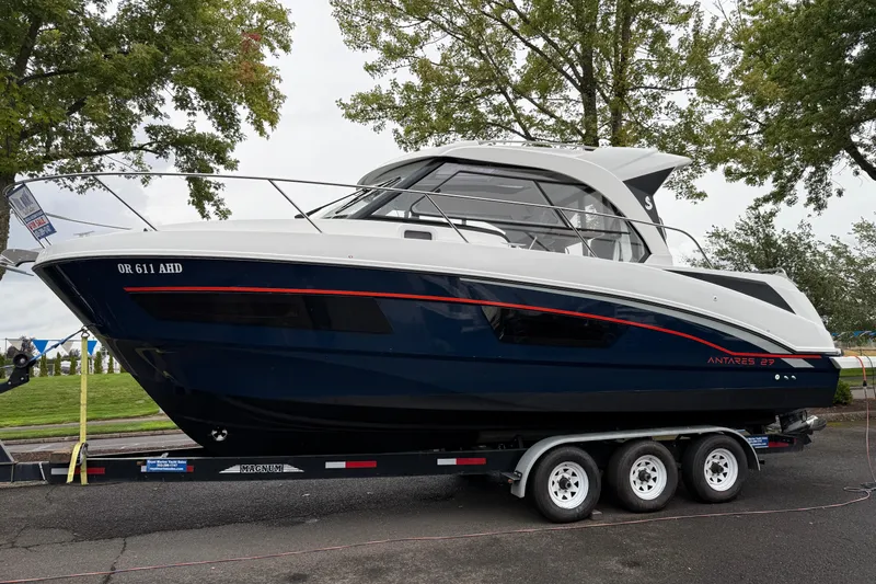  Yacht Photos Pics 2021 Beneteau Antares 9 boat on trailer, parked outdoors with trees in background.