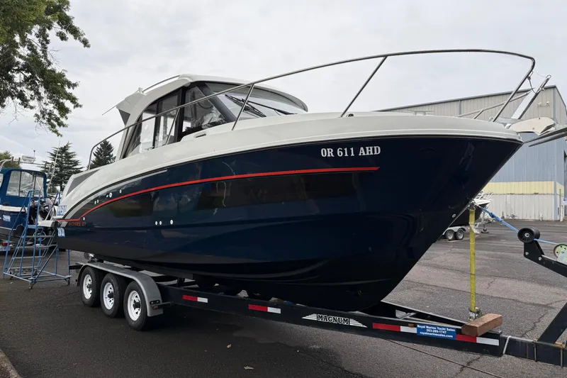  Yacht Photos Pics 2021 Beneteau Antares 9 boat on trailer, parked outdoors near a warehouse.
