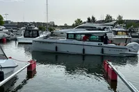 2022 Saxdor 320 GTC boat docked in a marina with other vessels.
