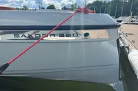 2022 Saxdor 320 GTC boat docked, featuring sleek design and red mooring line.