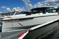 2022 Saxdor 320 GTC boat docked on water under a partly cloudy sky.
