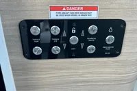 Control panel on 2022 Saxdor 320 GTC boat with warning label and various switches.