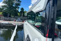 2022 Saxdor 320 GTC boat docked by a scenic waterfront.