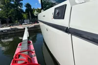 2022 Saxdor 320 GTC boat docked, side view with red rope and water reflection.
