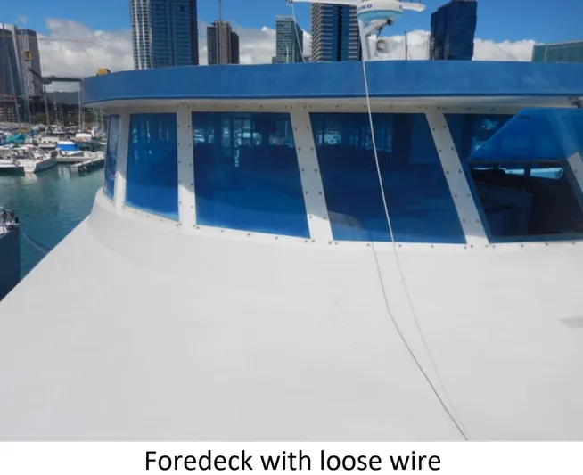  Yacht Photos Pics Custom 2010 Semi Sub Power Catamaran foredeck with loose wire, city skyline in background.