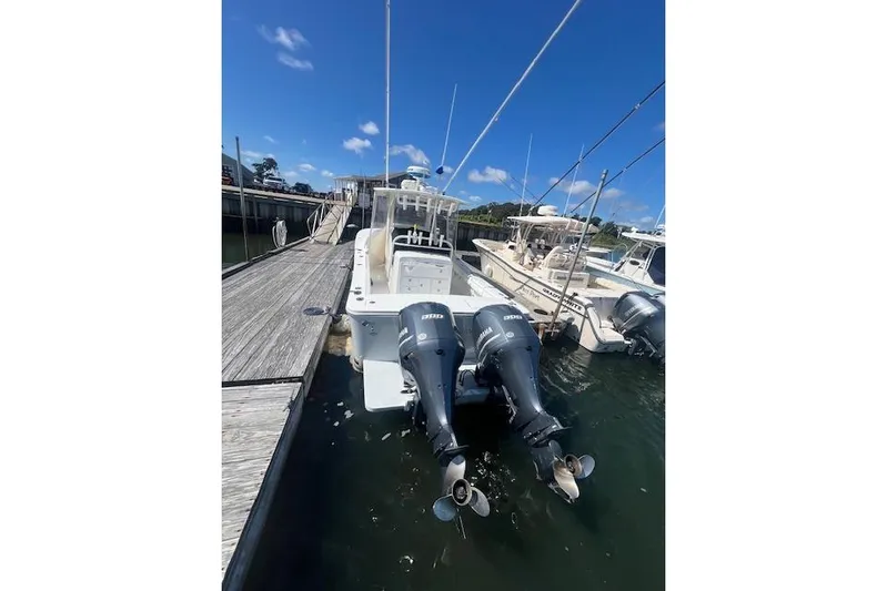 Tesoro Mio Yacht Photos Pics 2017 Regulator 31 boat docked with twin outboard engines under a clear blue sky.