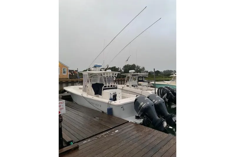 Tesoro Mio Yacht Photos Pics 2017 Regulator 31 boat docked with dual outboard engines, overcast sky.
