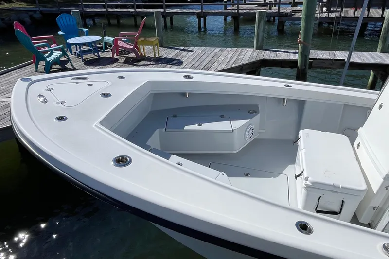  Yacht Photos Pics 2023 Pair Customs 24 Center Console DV boat docked with colorful chairs nearby.