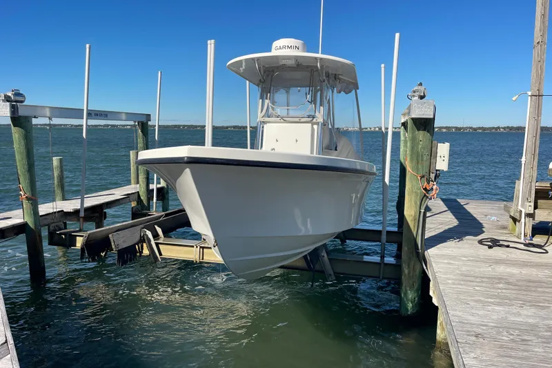  Yacht Photos Pics 2023 Pair Customs 24 Center Console DV boat docked on a lift by the water.