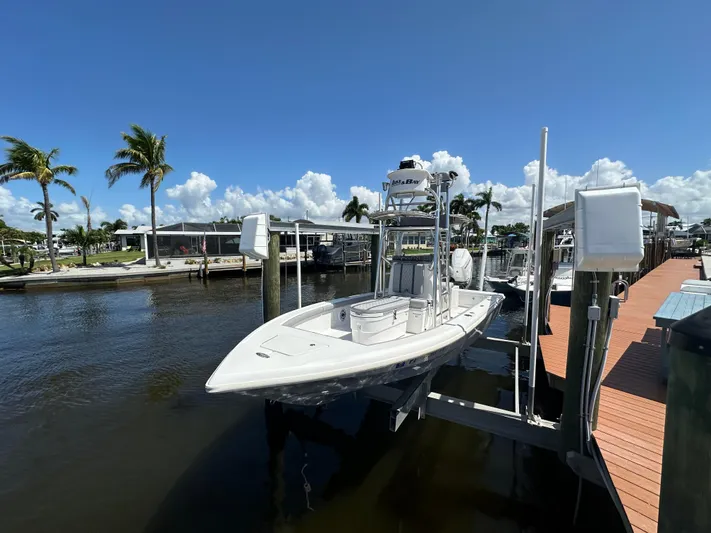  Yacht Photos Pics 2024 Lake & Bay 25 Open boat docked by palm trees under a clear blue sky.