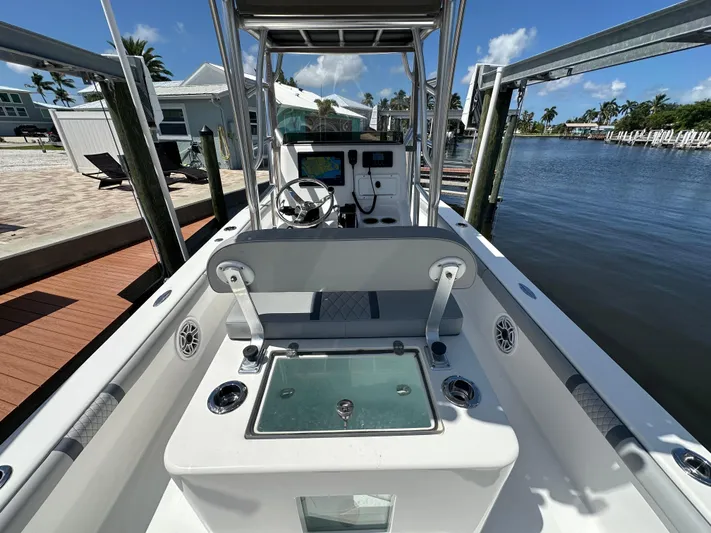  Yacht Photos Pics 2024 Lake & Bay 25 Open boat interior with console and seating, docked by waterfront.