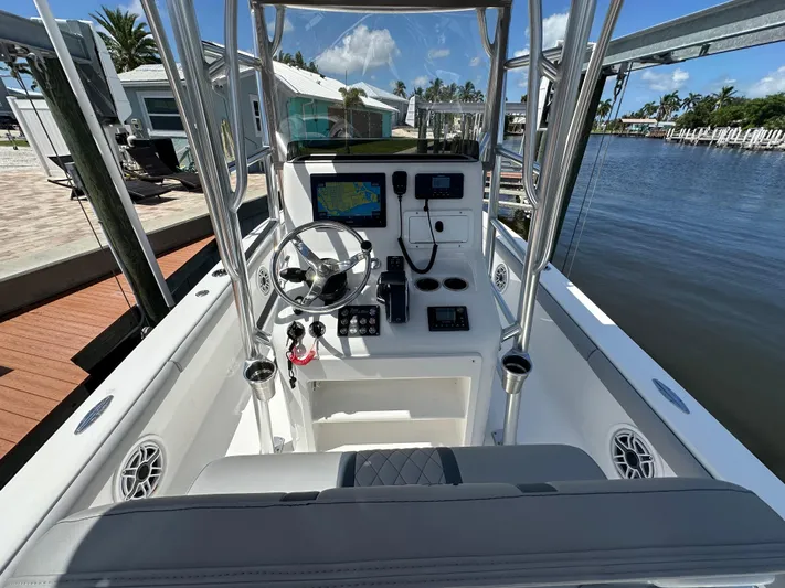  Yacht Photos Pics 2024 Lake & Bay 25 Open boat cockpit with modern navigation equipment, docked by a serene waterfront.