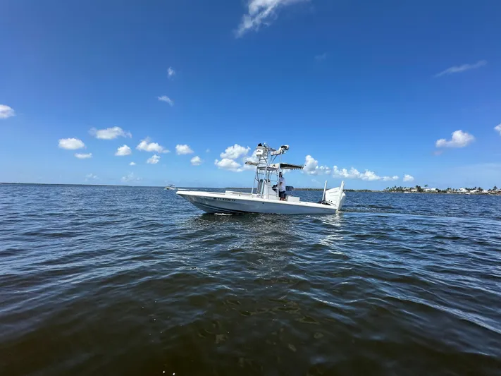  Yacht Photos Pics 2024 Lake & Bay 25 Open boat on calm waters under clear blue sky.