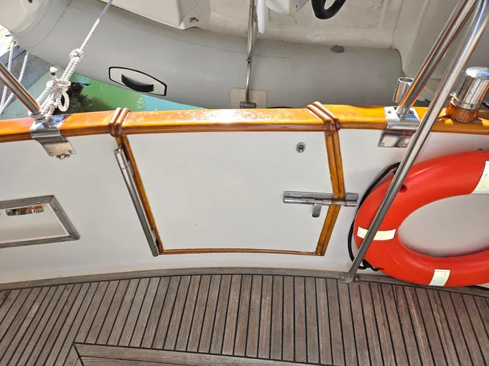 Carina Yacht Photos Pics Deck view of 1990 Grand Banks 36 Europa with life preserver and wooden railing.