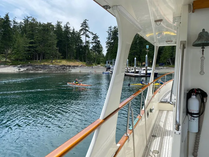 Carina Yacht Photos Pics Grand Banks 36 Europa yacht near a scenic shoreline with kayakers and a marina.